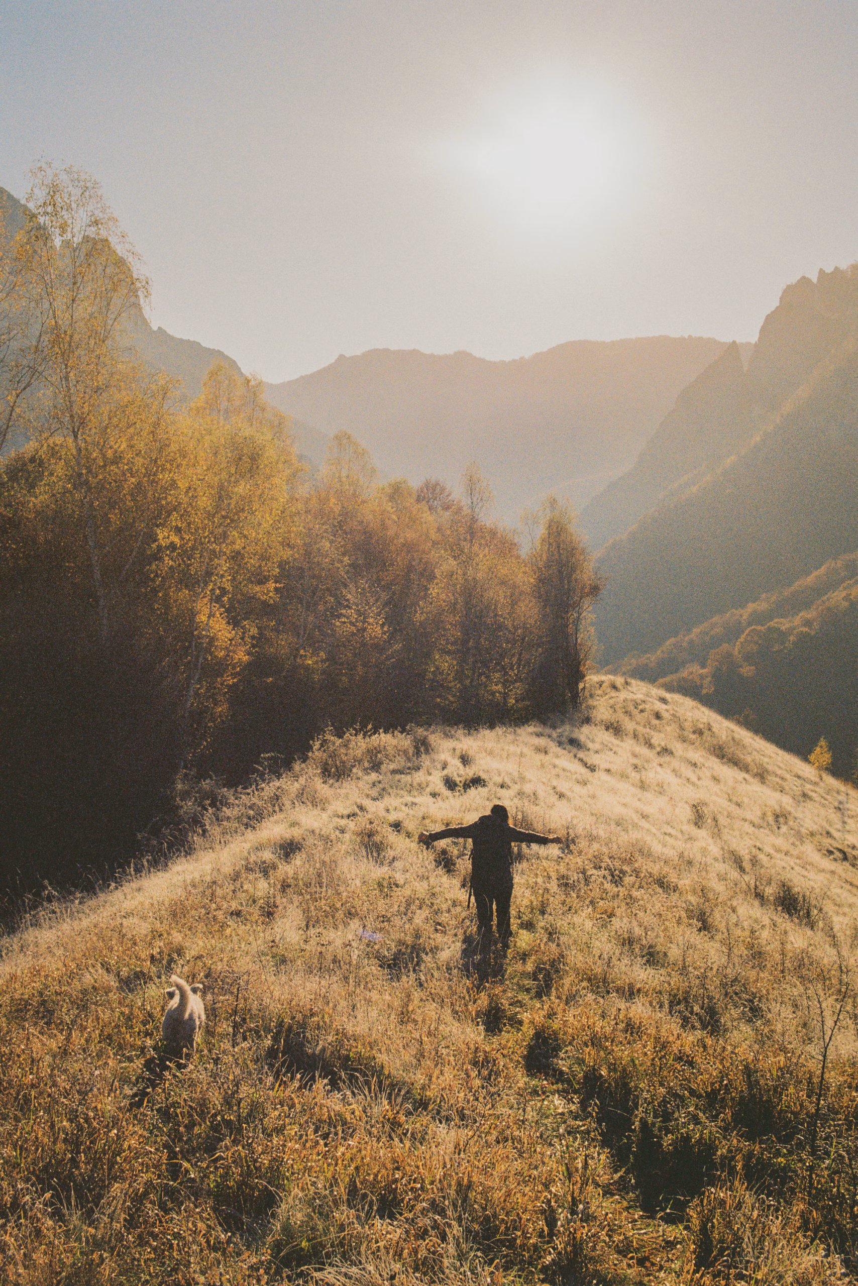 Eliane zum Sonnenaufgang am Hügel mit ausgestreckten Armen